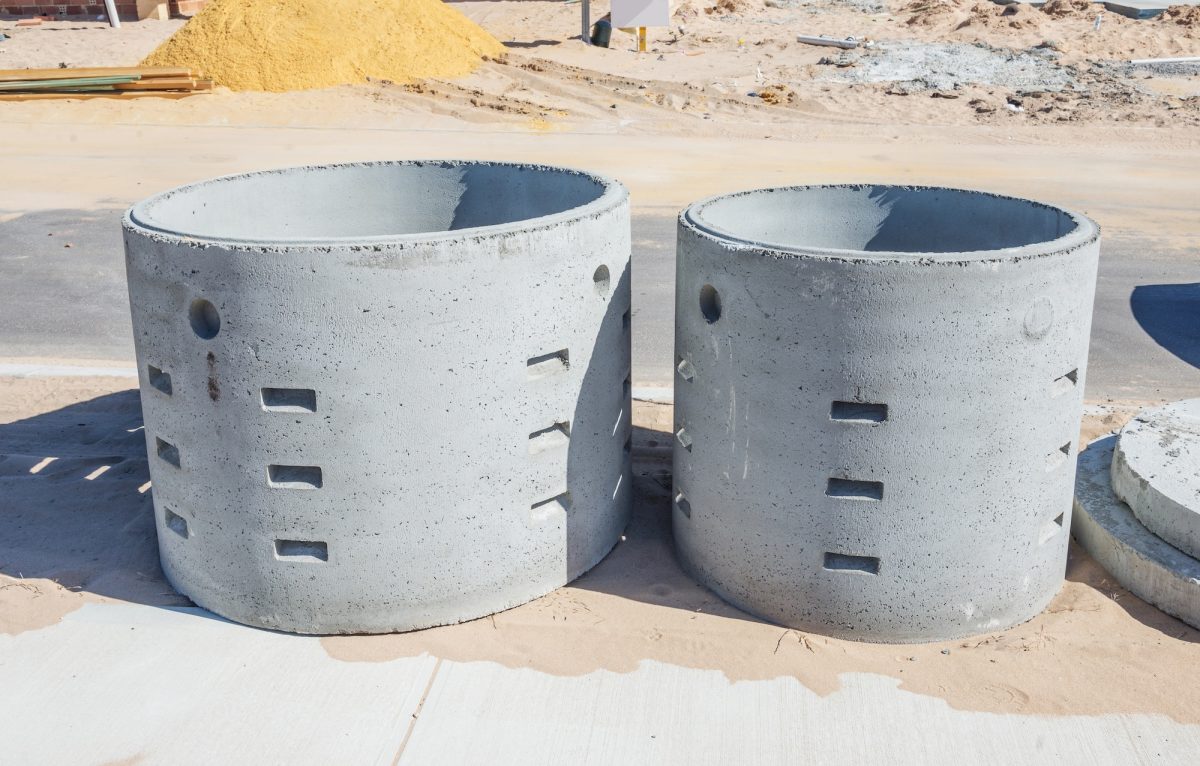 Concrete soakwell liners on a building site ready for installation